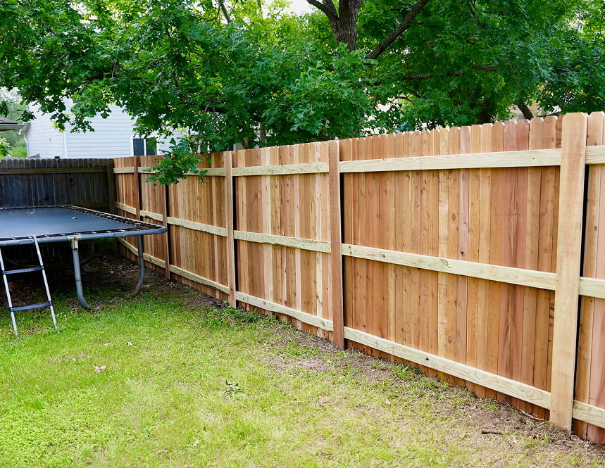 A finished cedar privacy fence in an Austin backyard